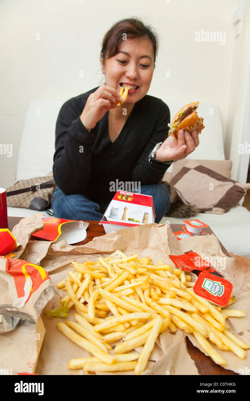 Woman eating hamburger et frites Banque D'Images