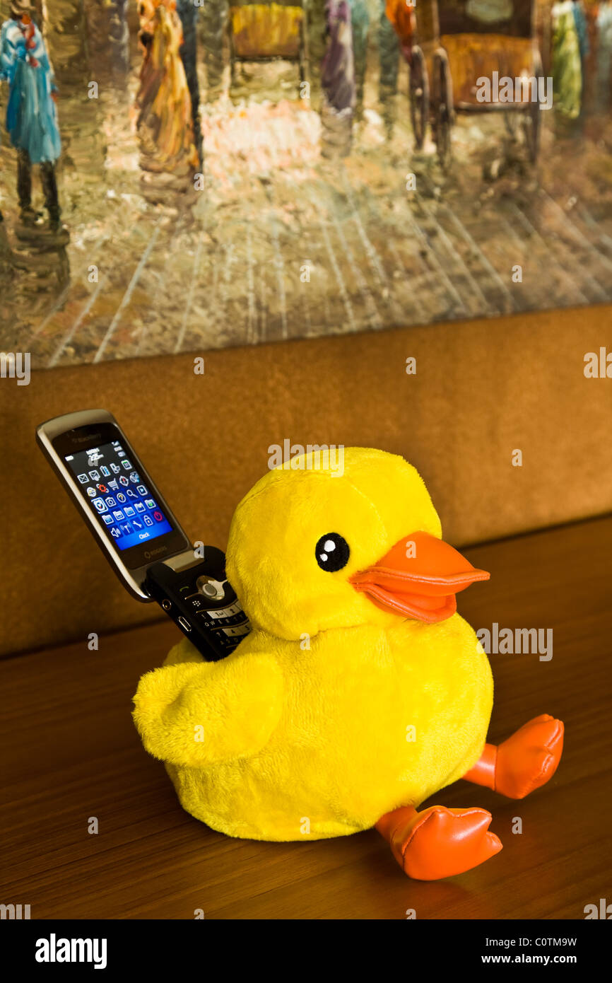 Un jouet en peluche canard utilisé comme support de téléphone mobile Banque D'Images