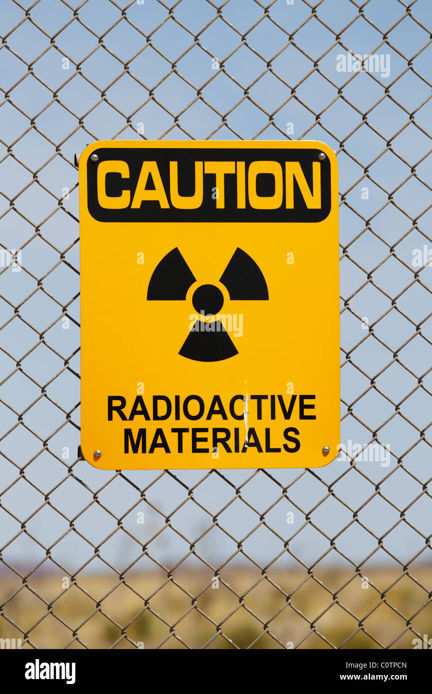 Un signe d'avertissement sur les matières radioactives sur une clôture métallique au site Trinity, Nouveau-Mexique. Banque D'Images