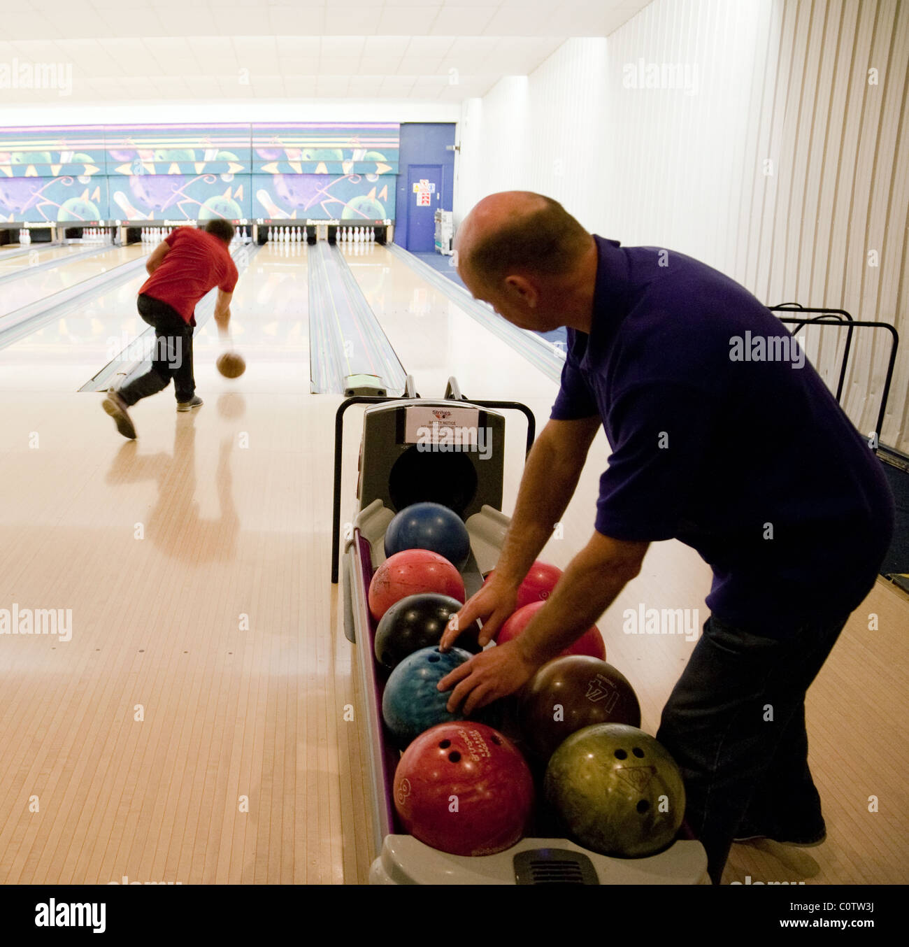 Deux hommes à dix quilles au 'Strikes' bowling, Ely, UK Banque D'Images