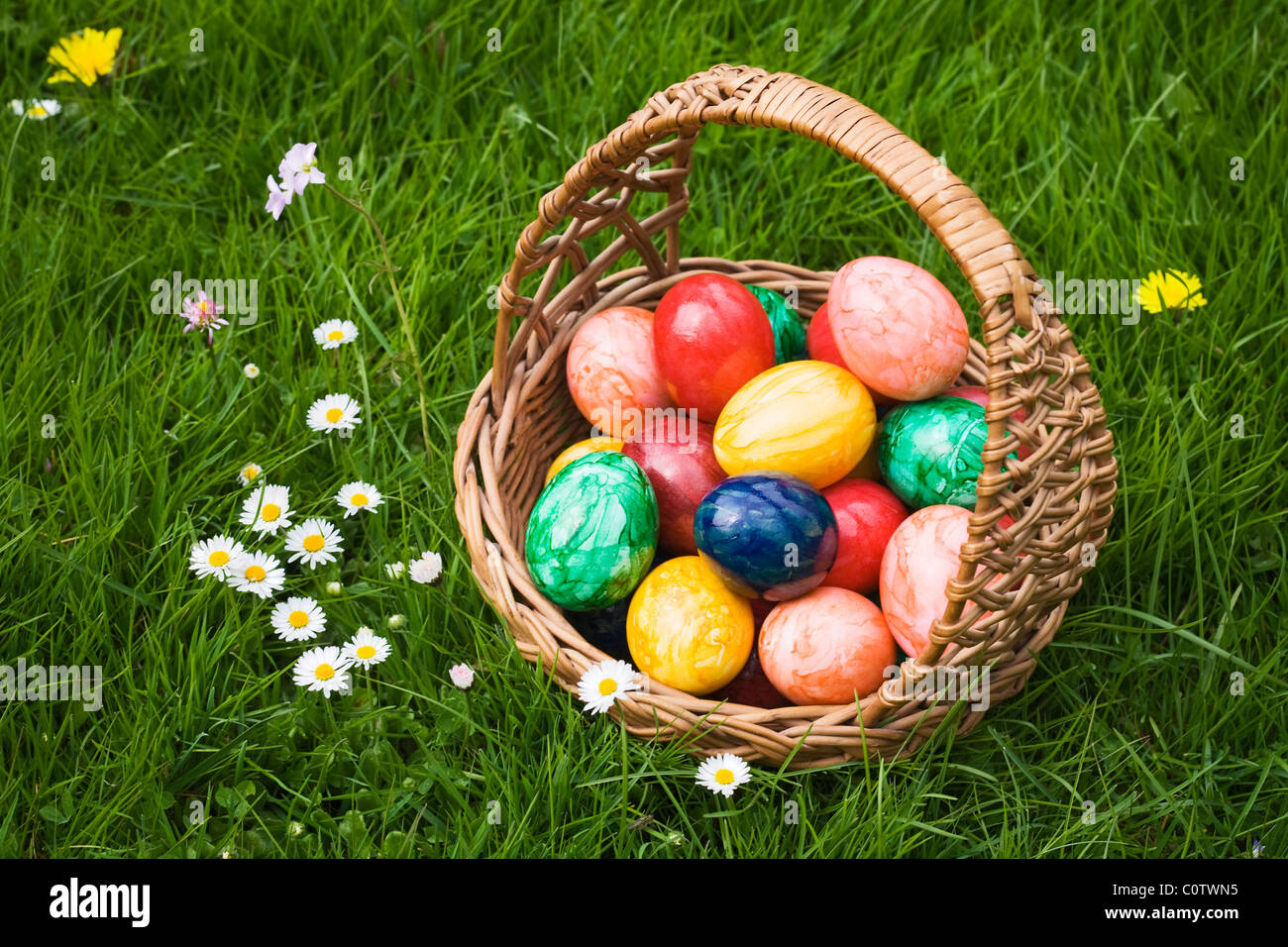 Panier plein d'œufs de Pâques dans l'herbe Banque D'Images