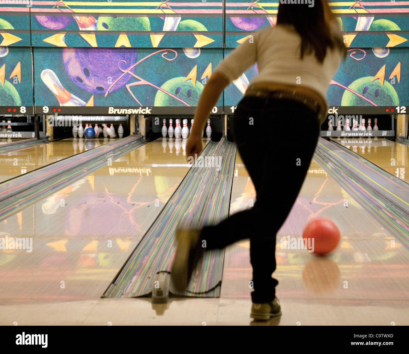 Jeune femme à dix quilles au 'Strikes' bowling, Ely, UK Banque D'Images