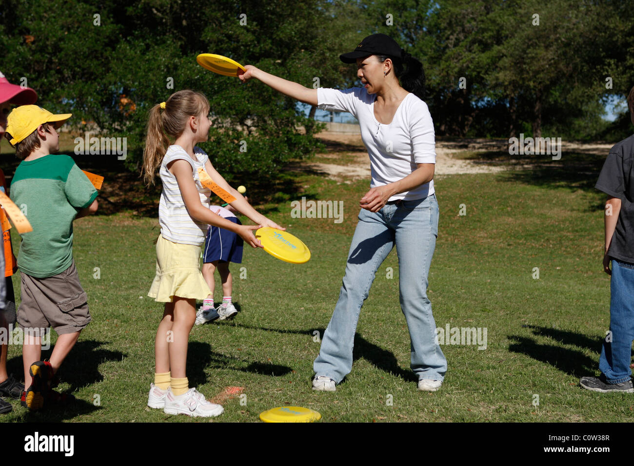 Demande de bénévolat pour les parents des élèves de troisième sur la façon de lancer un Frisbee au cours du printemps de l'école primaire de field day à Austin Banque D'Images