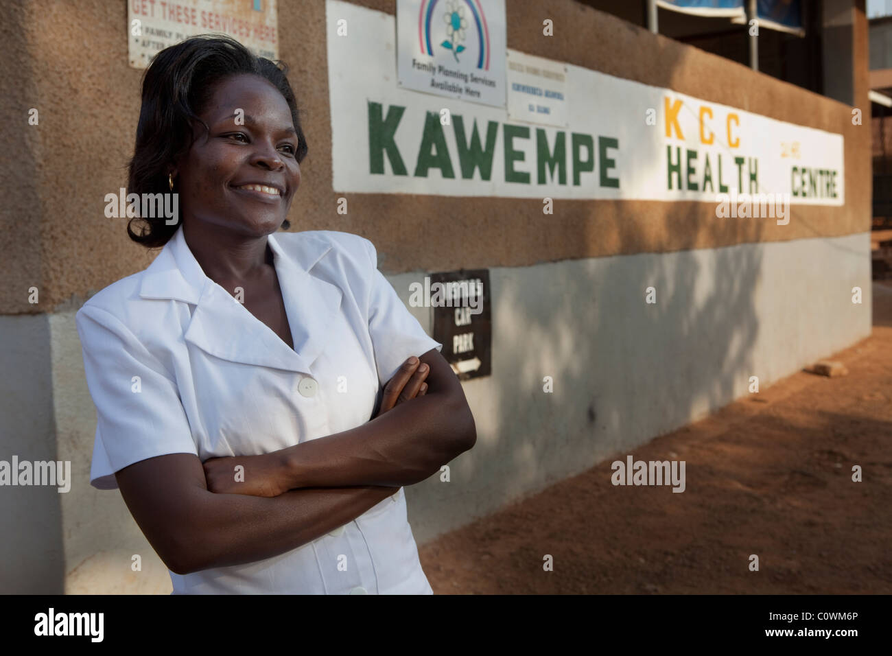 Une infirmière se trouve à l'extérieur Kawembe Health Centre à Kampala, Ouganda. Banque D'Images