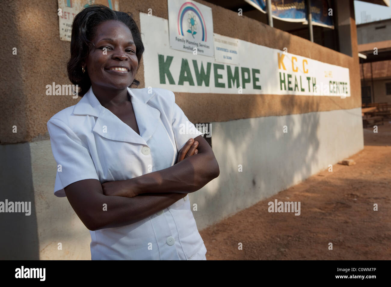 Une infirmière se trouve à l'extérieur Kawembe Health Centre à Kampala, Ouganda. Banque D'Images