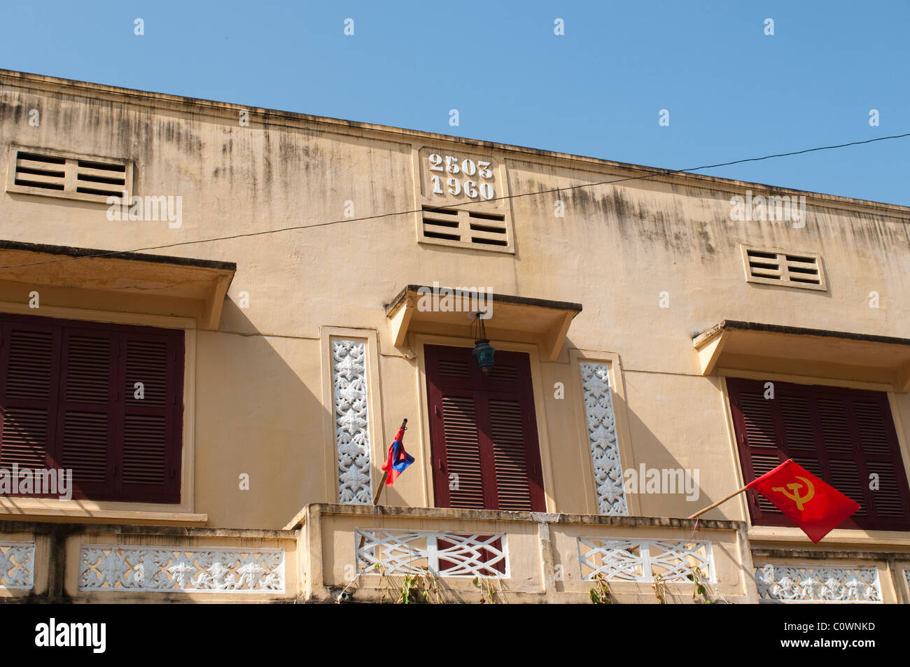 Maison construite en 2503, année d'ajo sinon 1960, et un drapeau communiste, Luang Prabang, Laos Banque D'Images