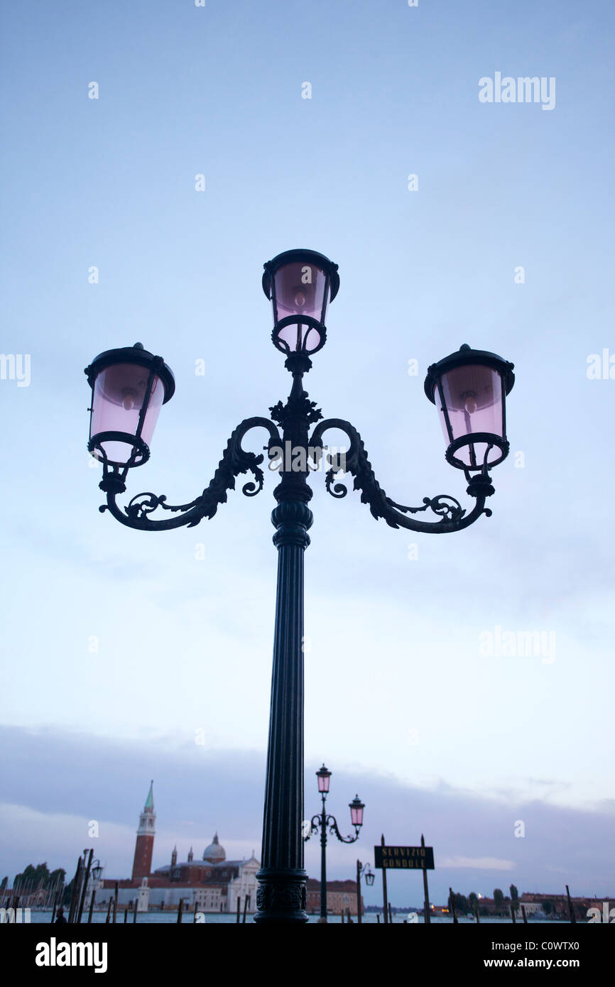 Un lampadaire lampe / le long de la rivière à Venise Italie avec une église en arrière-plan Banque D'Images