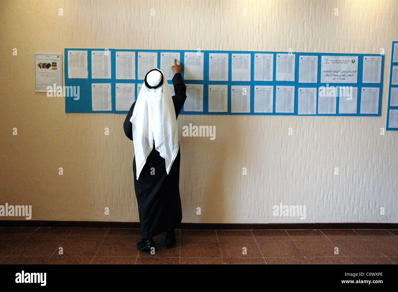 Un électeur recherche son nom à un bureau de vote à Paris, pendant les premières élections municipales dans le pays, l'Arabie Banque D'Images