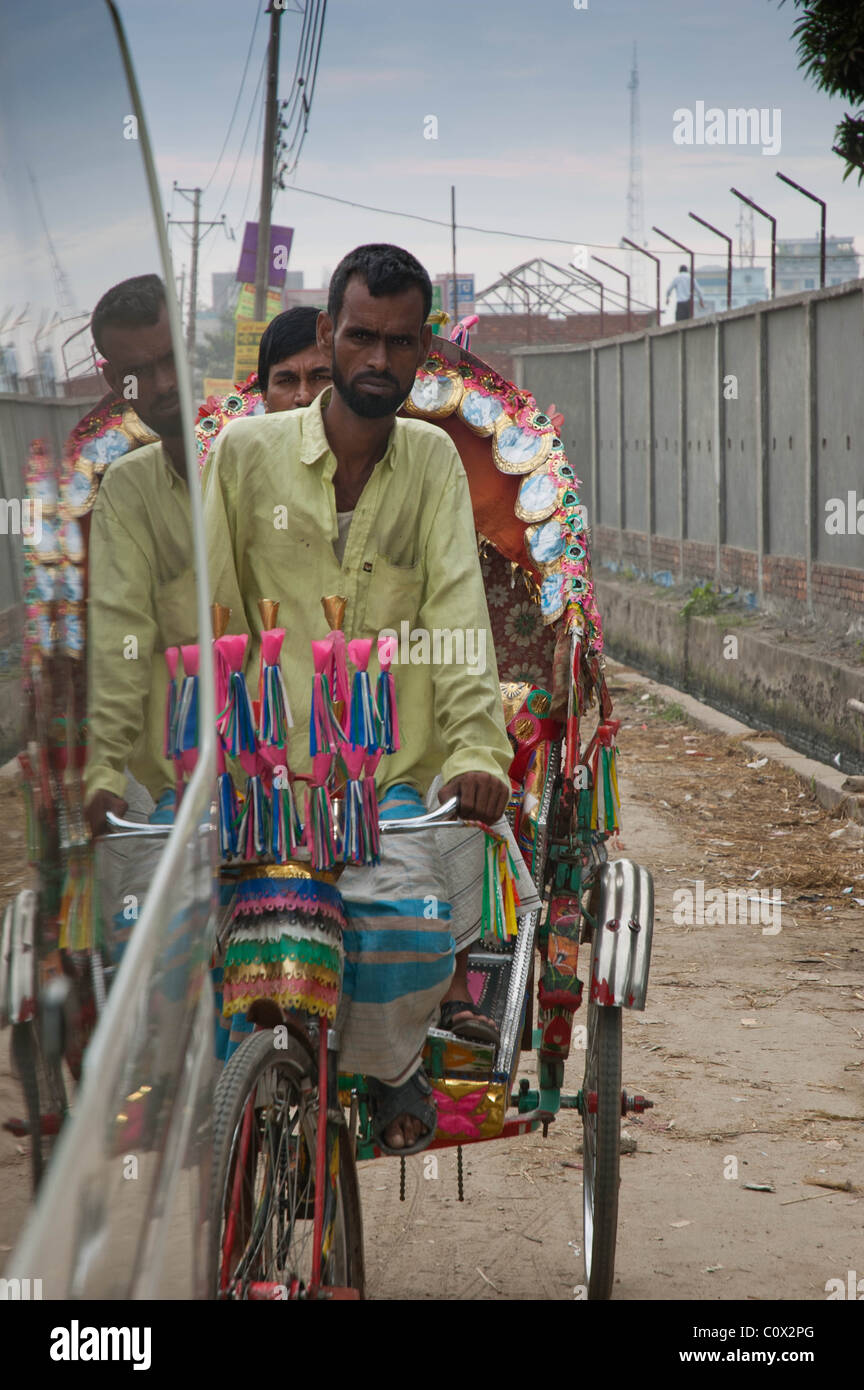 Un conducteur de pousse-pousse tente de passer à travers le trafic de daka, Bangladesh Banque D'Images