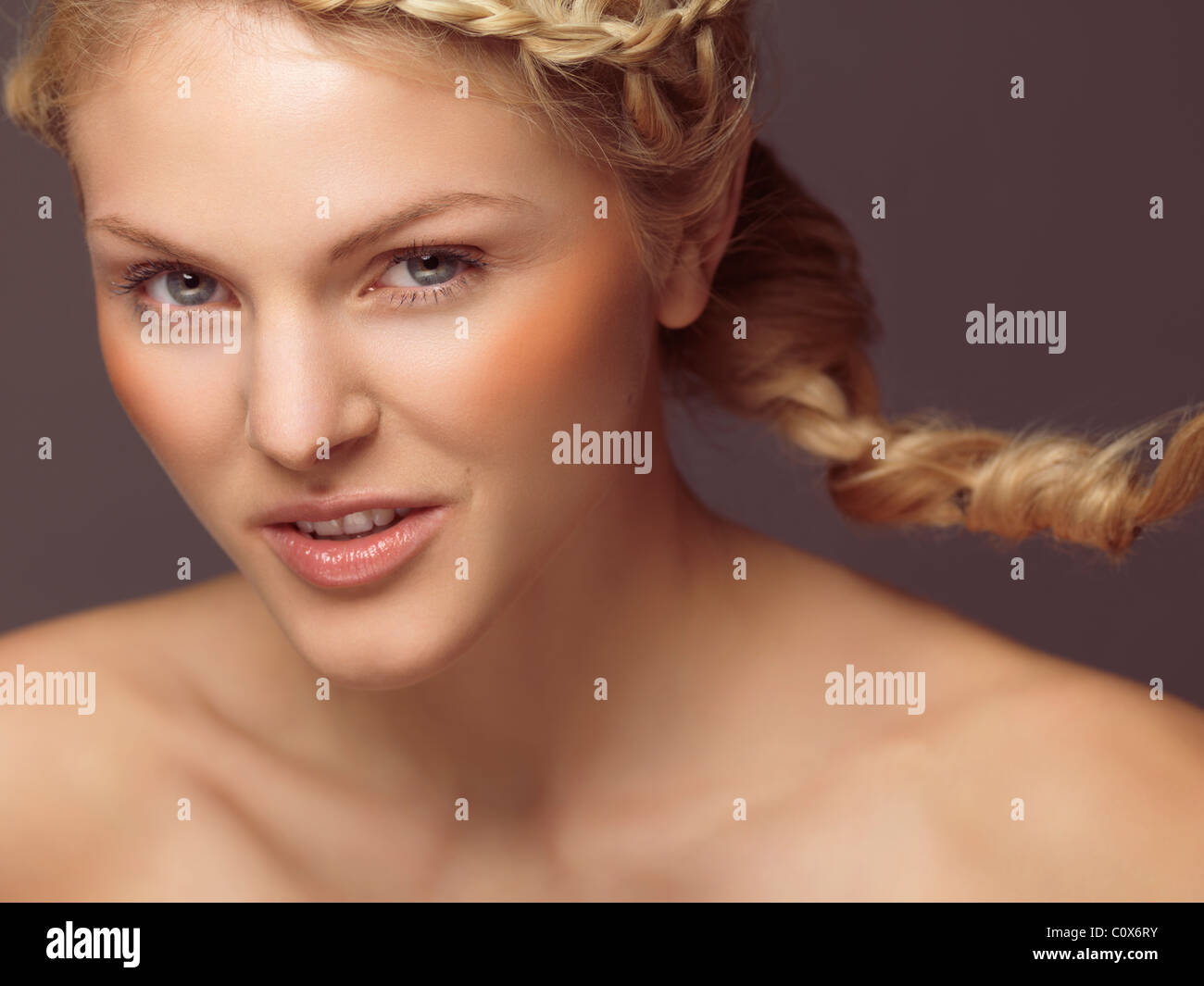 Portrait de beauté d'une jeune femme souriante avec une tresse et blush orange Banque D'Images