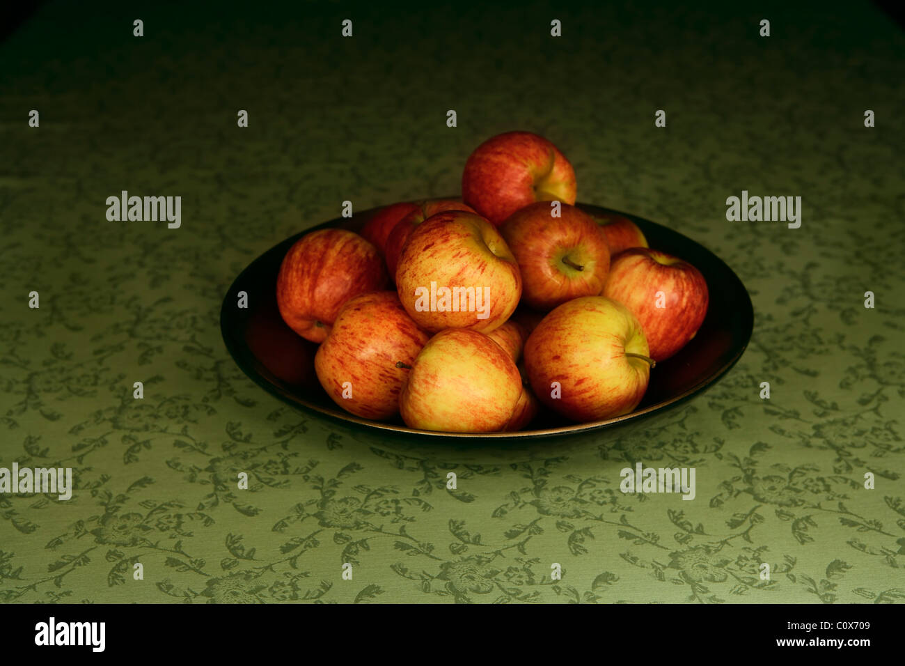 Bol de pommes sur une nappe verte Banque D'Images