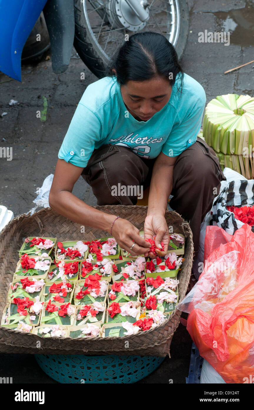 Femme vendant des pétales de fleurs pour la fabrication de produits offerts sur le marché à Ubud Bali Indonésie Banque D'Images