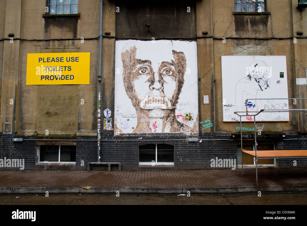Un morceau de l'art de rue sur un mur par l'artiste de rue Alexandre Farto (Vhils) près de Brick Lane, dans l'East End de Londres, au Royaume-Uni. Banque D'Images