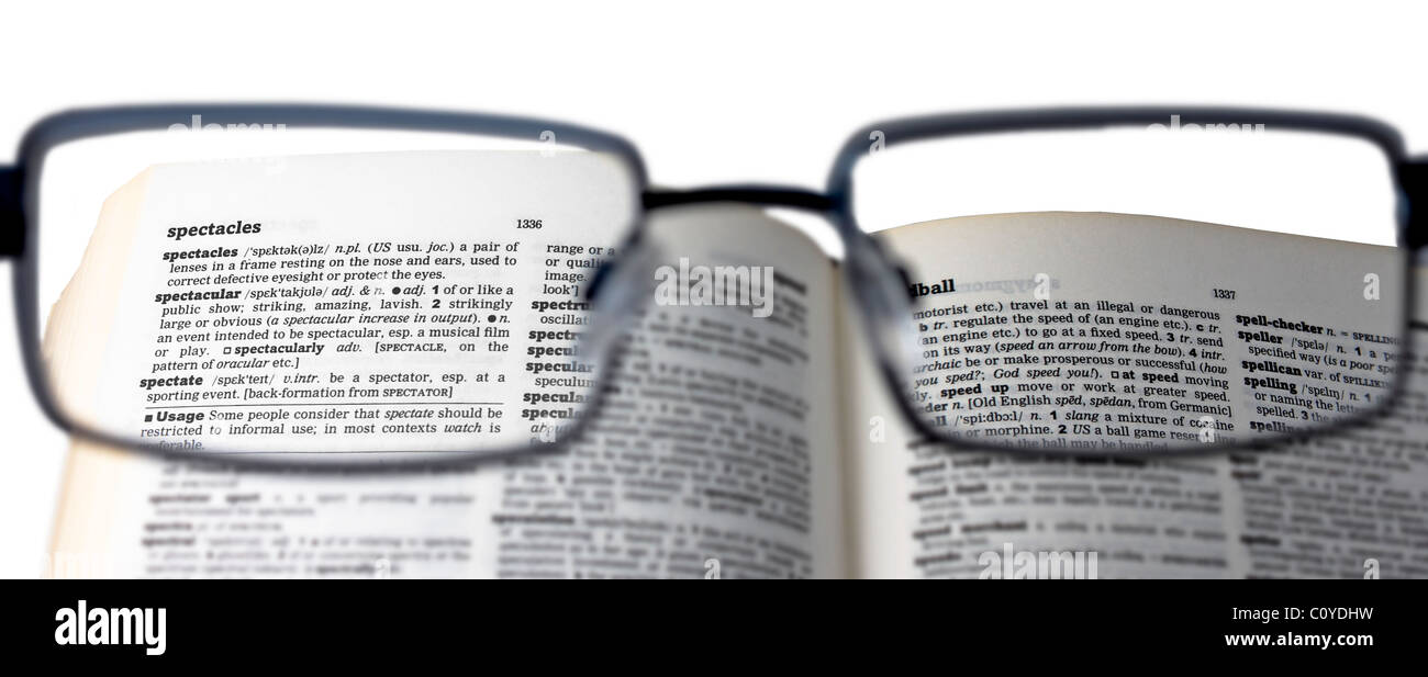 La lecture d'un dictionnaire avec lunettes pour lire la définition de 'spectacles' Banque D'Images