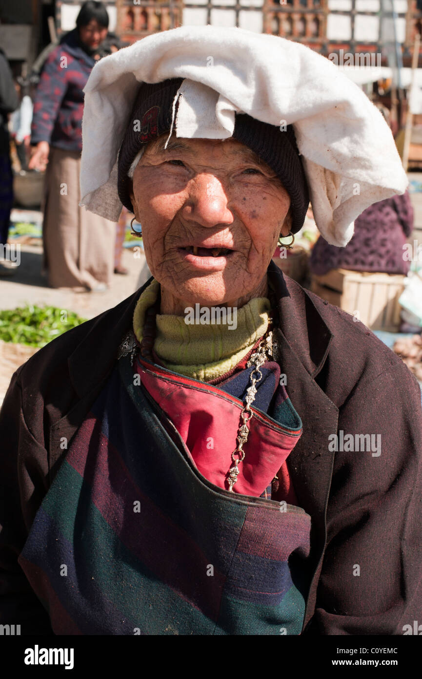 Bhoutanais âgées femme vendant ses marchandises dans un marché et ornée d'une coiffe blanche. Banque D'Images