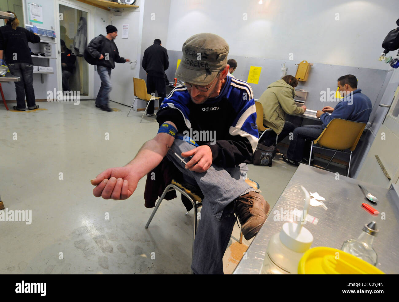 Un toxicomane en injection intraveineuse dans une galerie se "tirer", une chambre forte où les toxicomanes peuvent consommer de la drogue sous surveillance. Banque D'Images