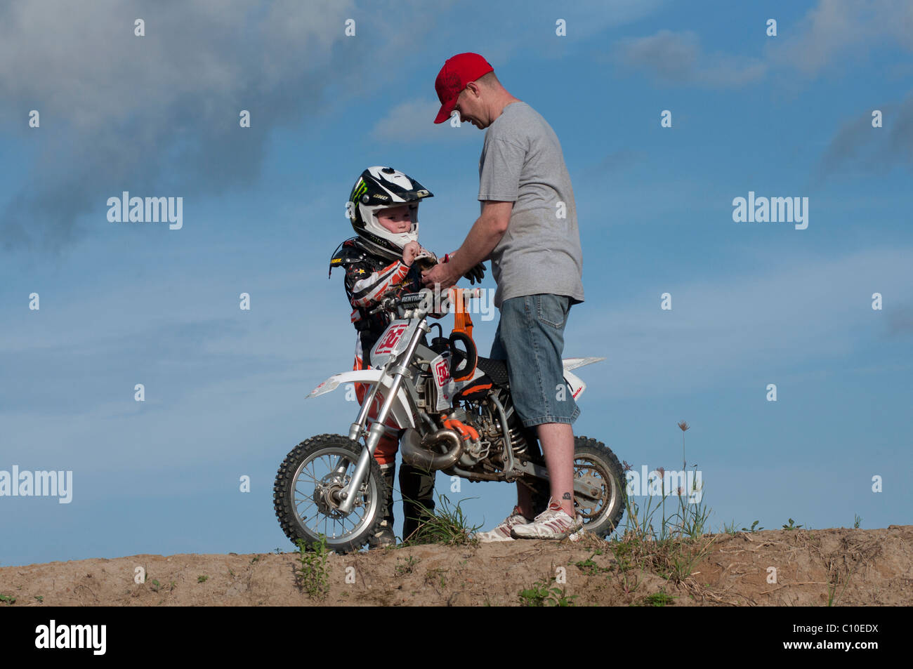 Un garçon de six ans avec son père et motocross bike Banque D'Images