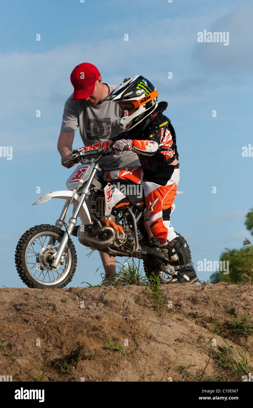 Un garçon de six ans avec son père et motocross bike Banque D'Images