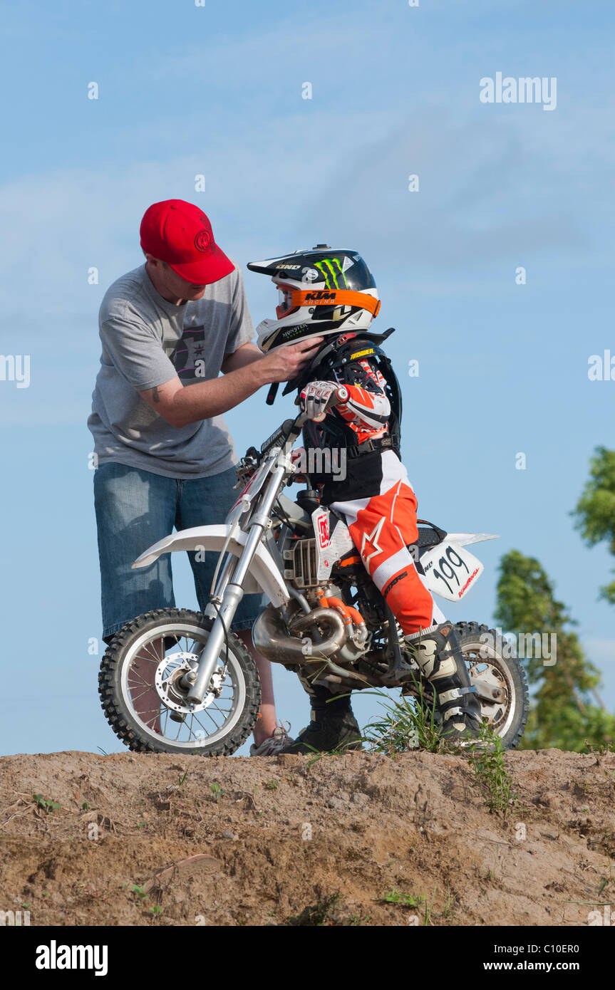 Un garçon de six ans avec son père et motocross bike Banque D'Images