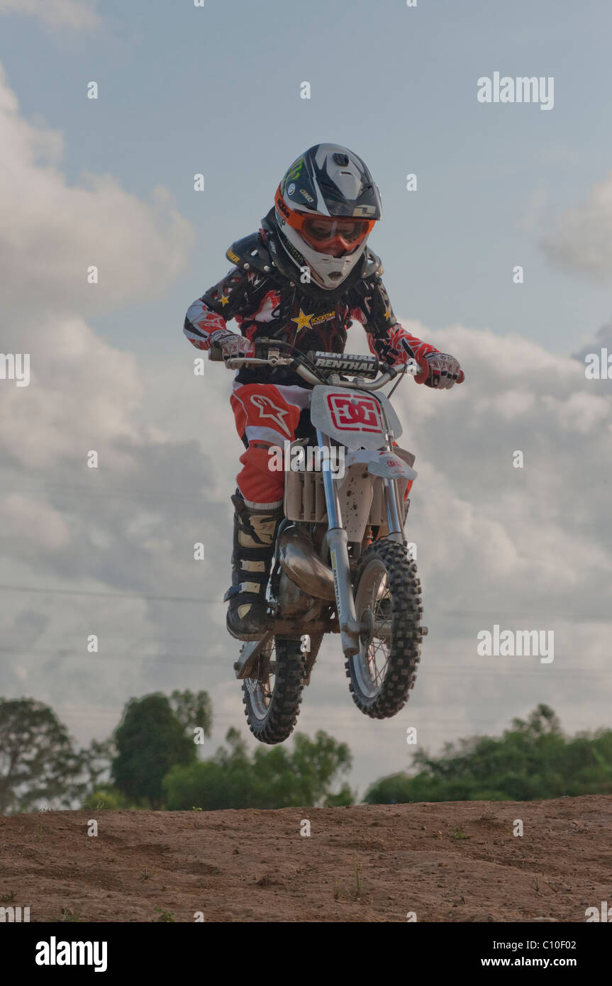 Un garçon de six ans avec son vélo motocross Banque D'Images