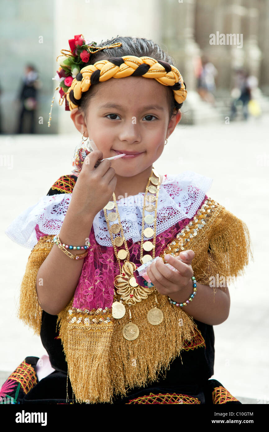 Petits Peuples mexican girl with lollipop en costume traditionnel sur la place devant la cathédrale principale de la ville d'Oaxaca au Mexique Banque D'Images