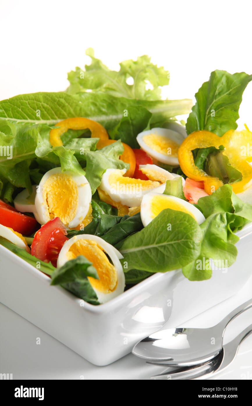 Un bol de salade de tomates et d'oeufs, avec de la laitue, le poivron, l'oignon et de la fusée. Banque D'Images