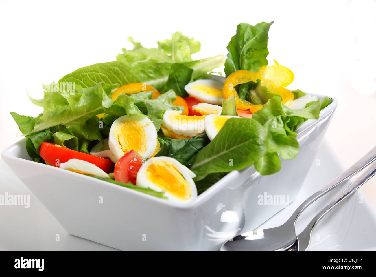 Un bol de salade de tomates et d'oeufs, avec de la laitue, le poivron, l'oignon et de la fusée. Banque D'Images