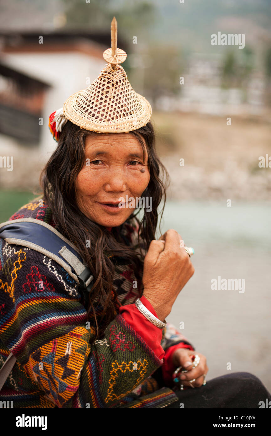 Laiya femme du Bhoutan de vendre ses marchandises à l'occasion d'un grand festival à Punakha, vêtu d'un chapeau de paille du Bhoutan et beau manteau tissé. Banque D'Images