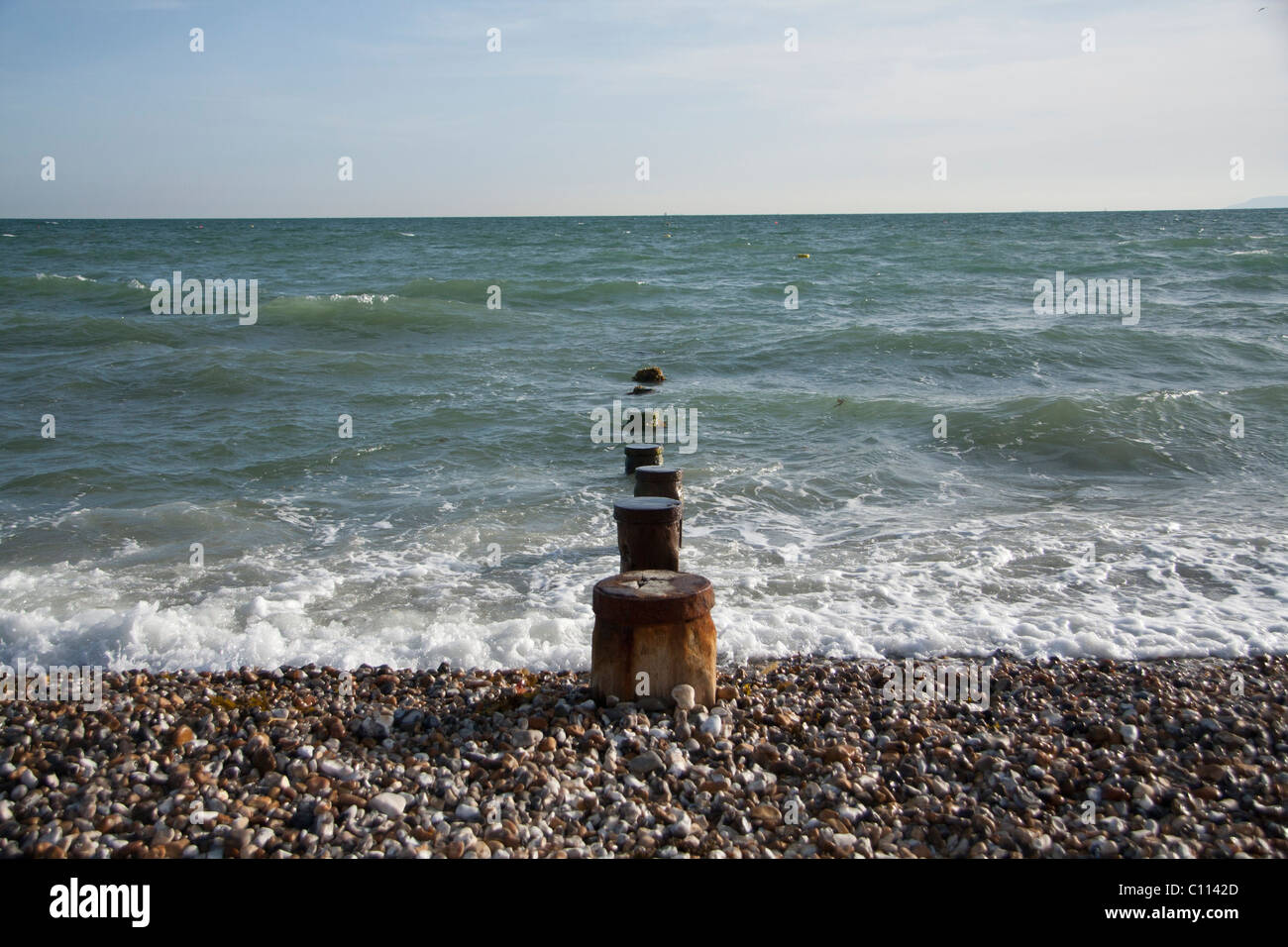 Stone beach et plage avec poteaux en bois Banque D'Images