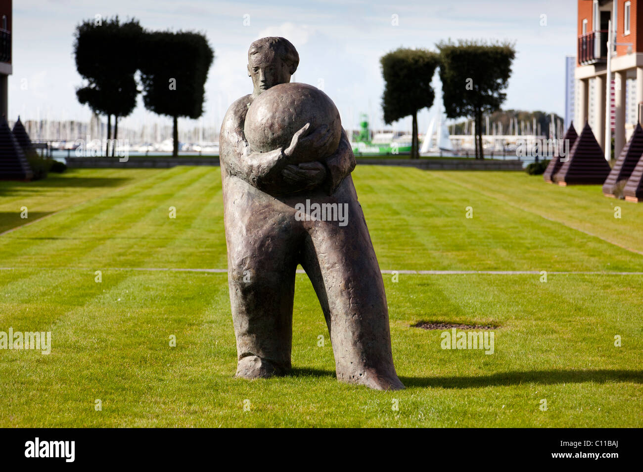 "L'homme et ball' sculpture par Giles Penny, en face de l'immeuble, Vulcan, PORTSMOUTH GUNWHARF QUAYS. Banque D'Images