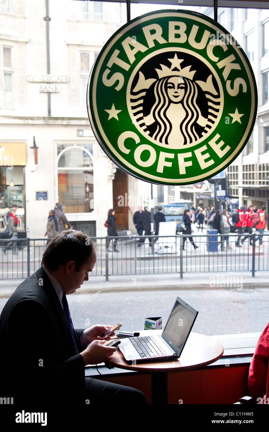 Travailleur de la ville sur l'ordinateur portable dans un café Starbucks Monument de Londres. Photo:Jeff Gilbert Banque D'Images