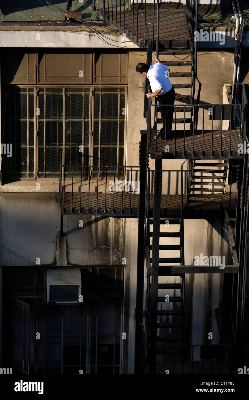 L'homme sur le dessus d'urgence échelles métalliques Banque D'Images