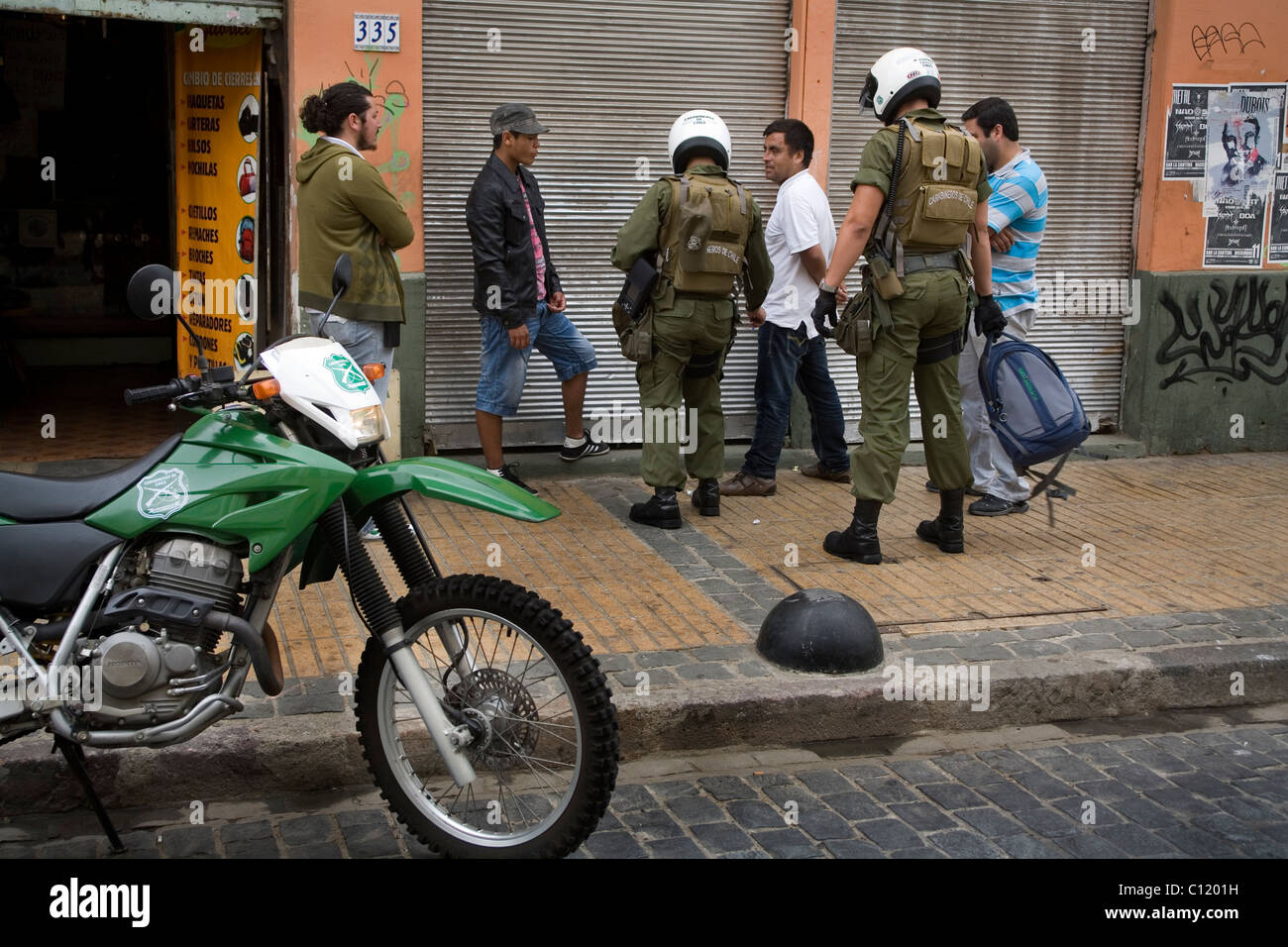 Carabiniers chiliens en civil et policier qui fait une arrestation dans la rue de Valparaiso au Chili Banque D'Images