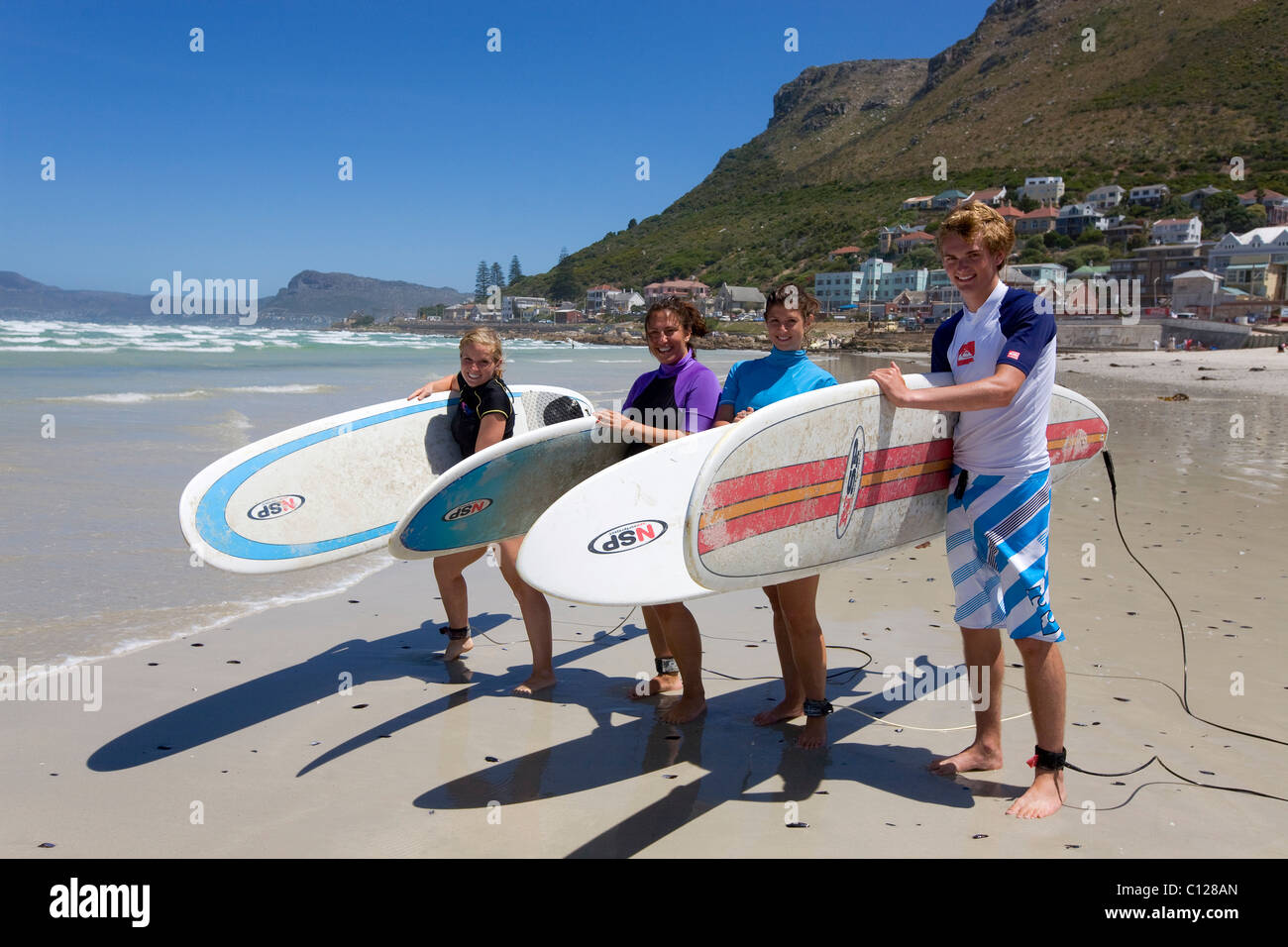 Groupe de jeunes surfeurs sur la plage de Muizenberg, Cape Town, Western Cape, Afrique du Sud, l'Afrique Banque D'Images