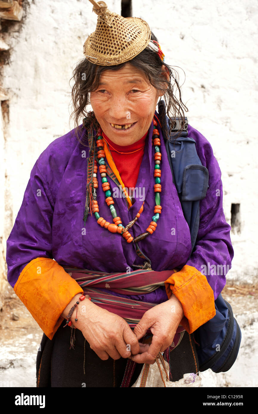 Laiya femme vêtue en habit traditionnel avec des colliers et de paille cap vend ses marchandises à un festival en milieu rural au Bhoutan Banque D'Images
