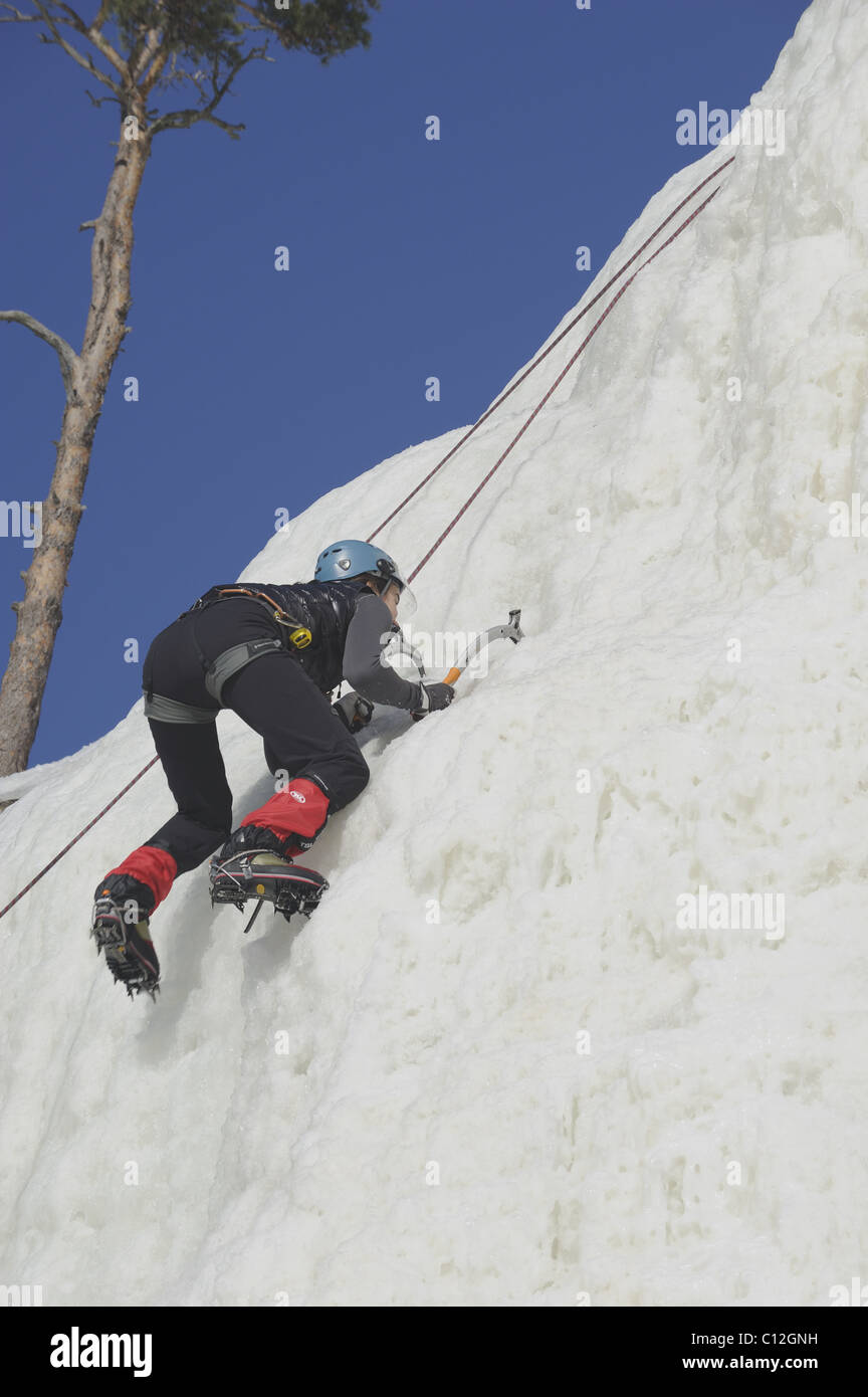 Une femme l'escalade de glace sur le Devil's Rock à Pikkukoski. Devil's Rock dispose d'un glacier artificiel pour les grimpeurs d'apprendre ice climbin Banque D'Images