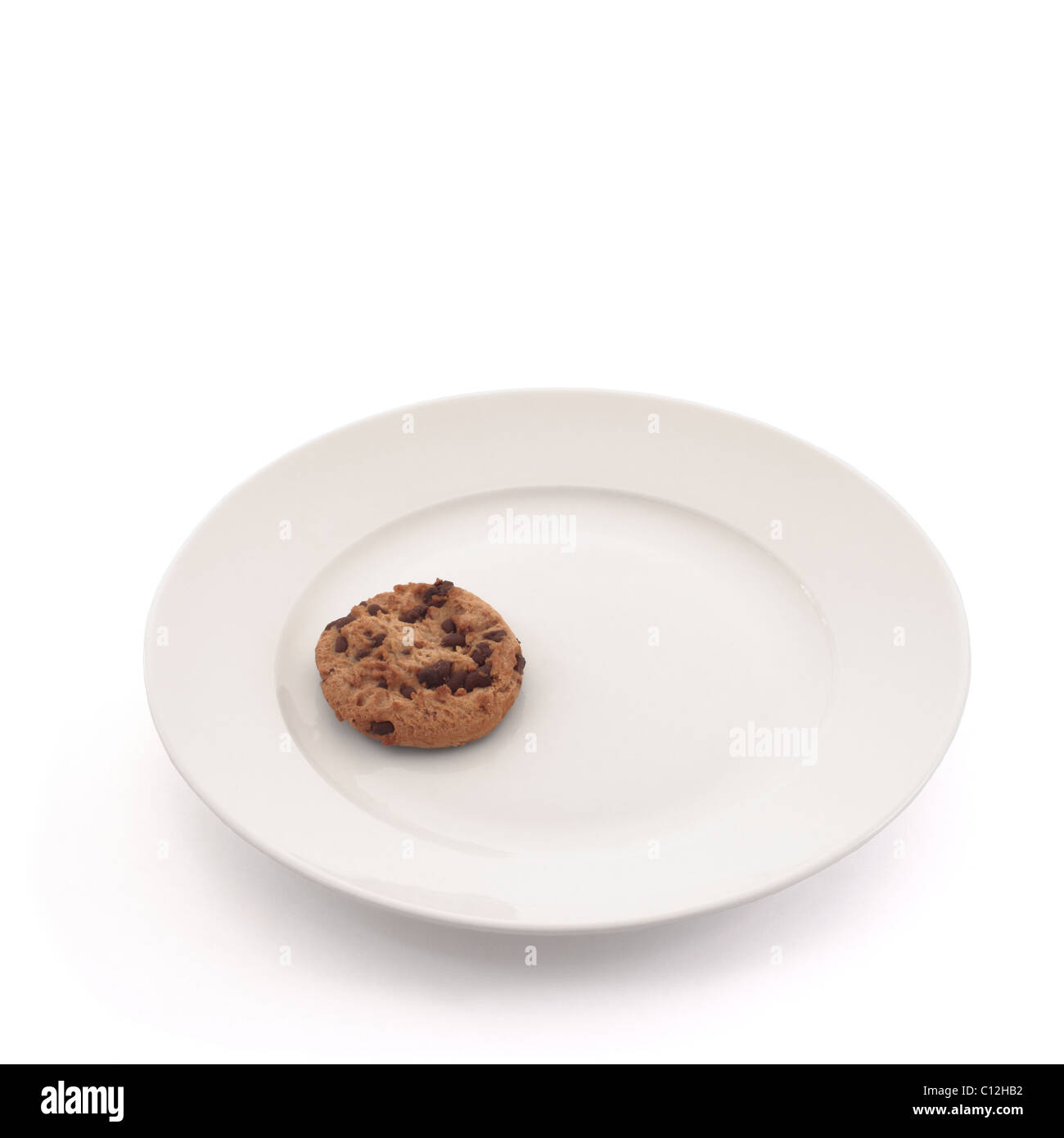 Seul biscuit sur une plaque blanche isolé sur fond blanc Banque D'Images