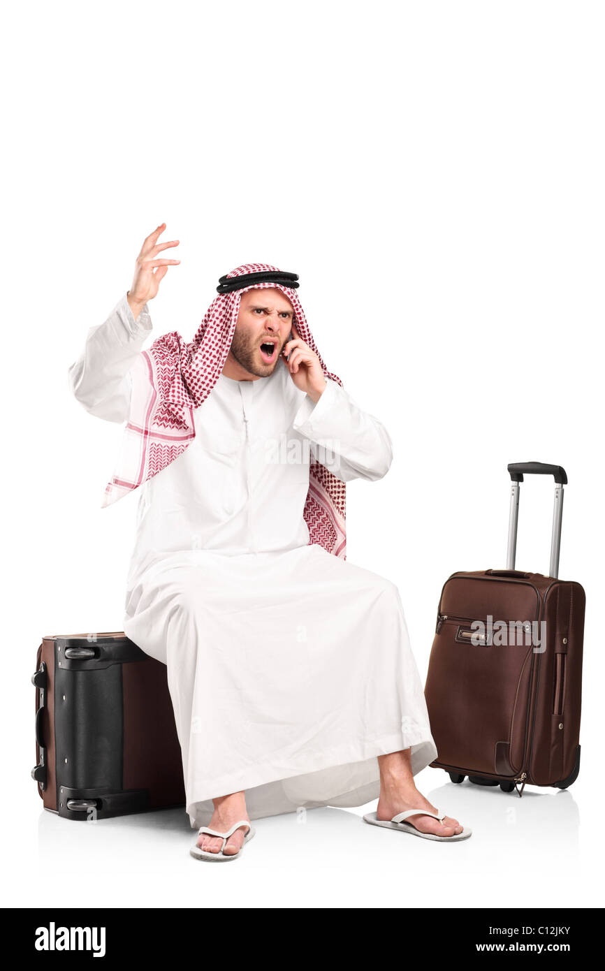 Un furieux cris arabes sur un téléphone mobile assis sur son assurance Banque D'Images