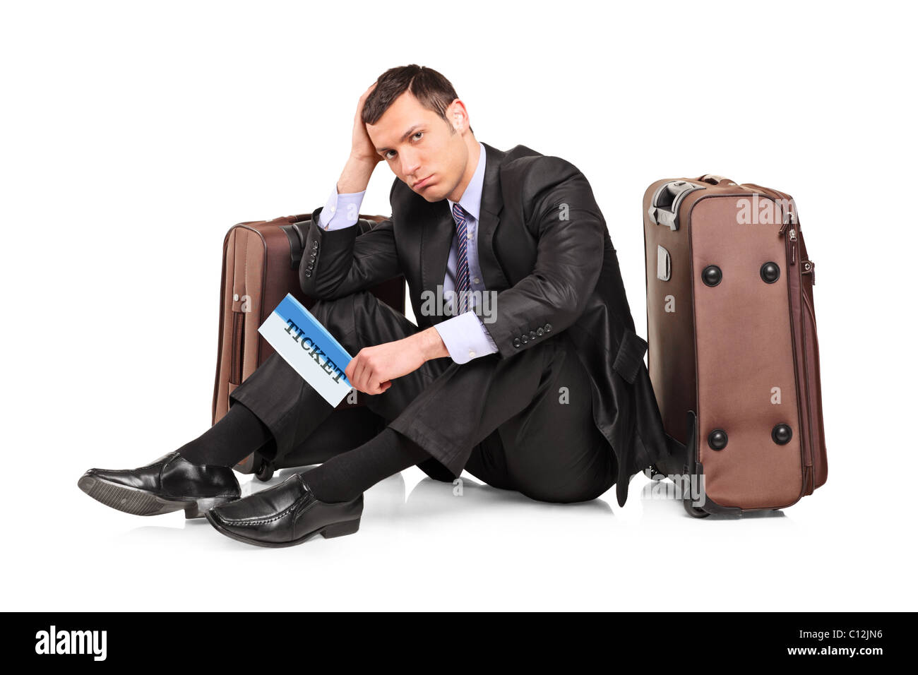 Une triste voyageur d'assis à côté d'une valise avec un ticket à la main Banque D'Images