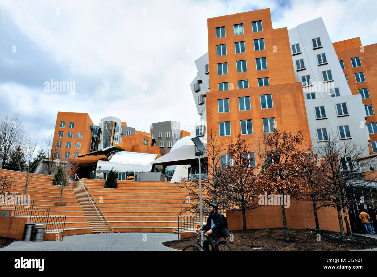 Des promenades en vélo jeunesse passé célèbre architecte Frank Gehry conçu Ray et Maria Stata Center du MIT, Massachusetts Institute of Technology, Cambridge MA, USA Banque D'Images
