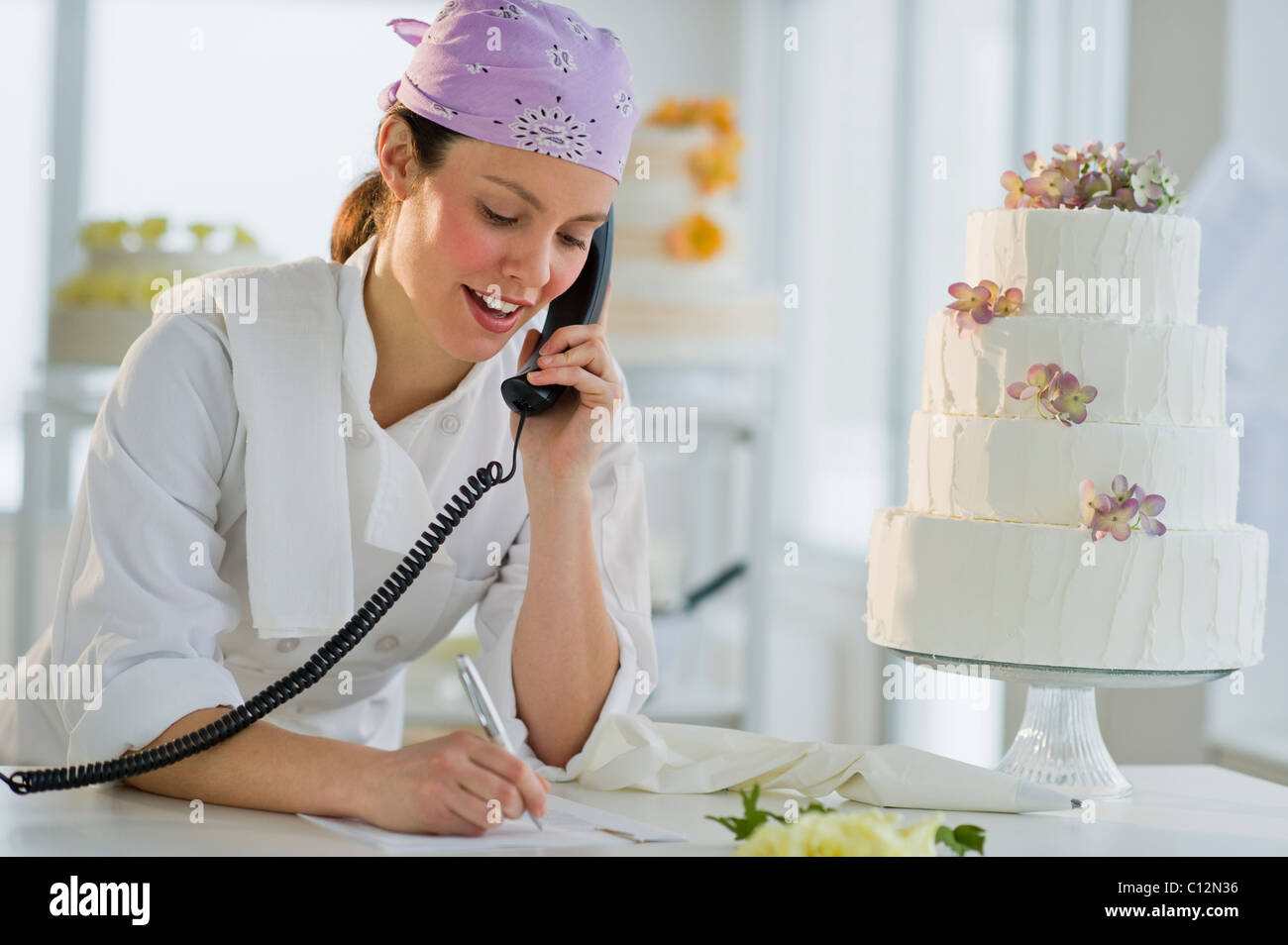 USA, New Jersey, Jersey City, Happy young woman taking order près de gâteau de mariage Banque D'Images