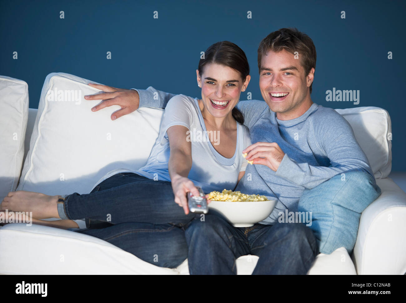 Couple sitting in front of television Banque D'Images