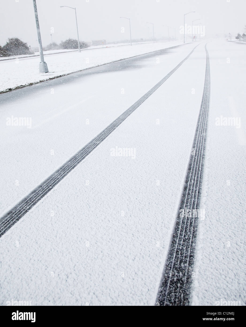 USA, New York State, Rockaway Beach, trace de pneu dans la neige sur la route Banque D'Images