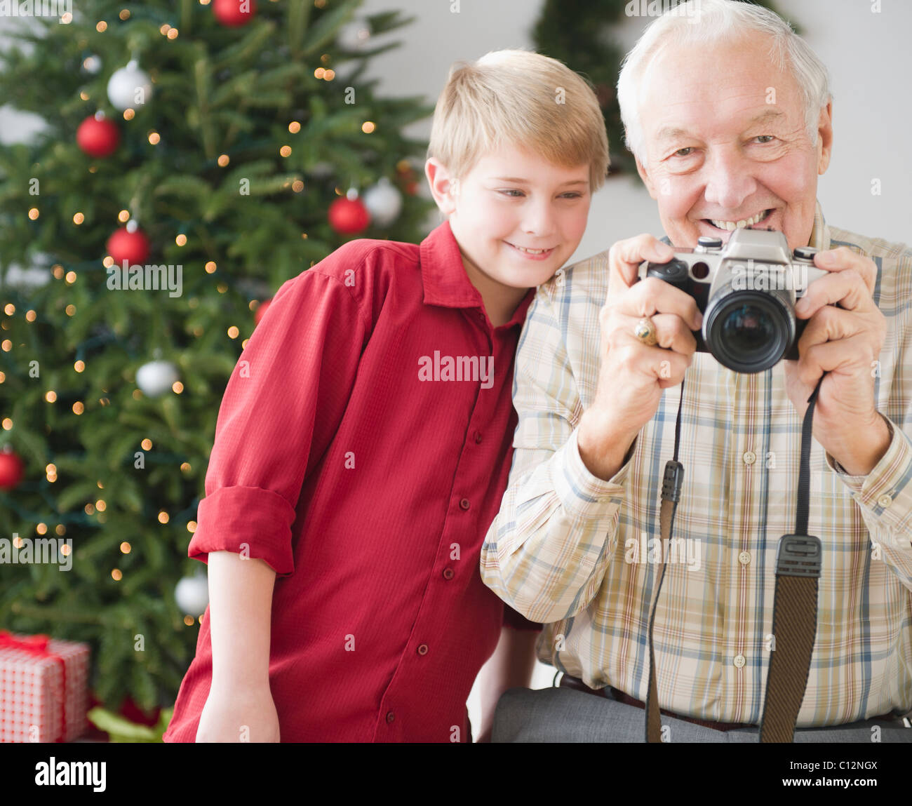 USA, New Jersey, Jersey City, grand-père et petit-fils (8-9 ans) de prendre photo, arbre de Noël en arrière-plan Banque D'Images