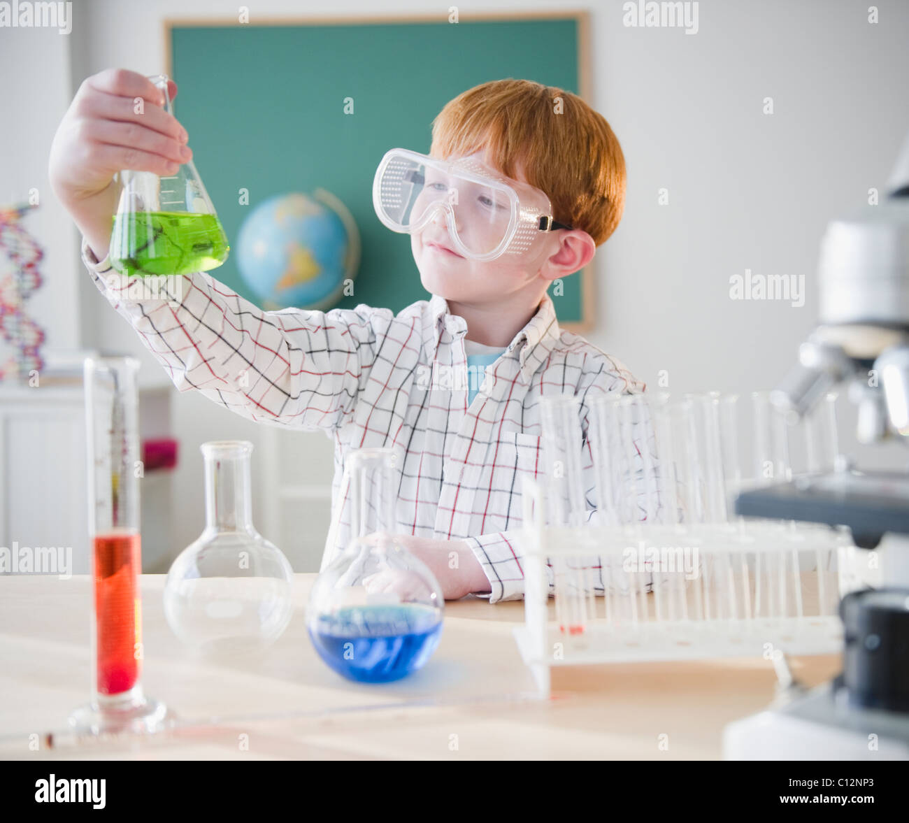 USA, New Jersey, Jersey City, Boy (8-9) holding chemical ballon dans science lab Banque D'Images