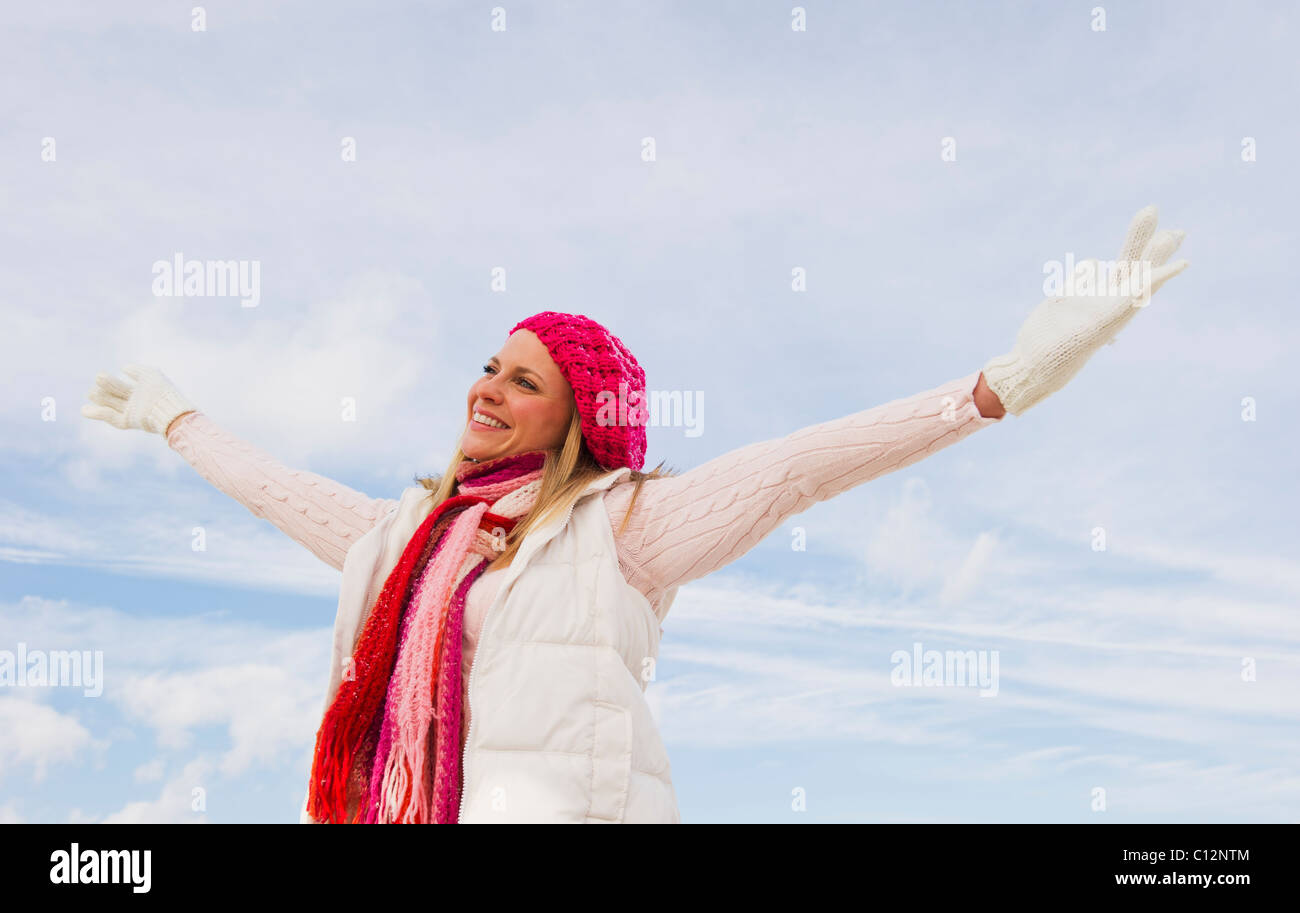 USA, New Jersey, Jersey City, woman in winter clothing raising arms Banque D'Images