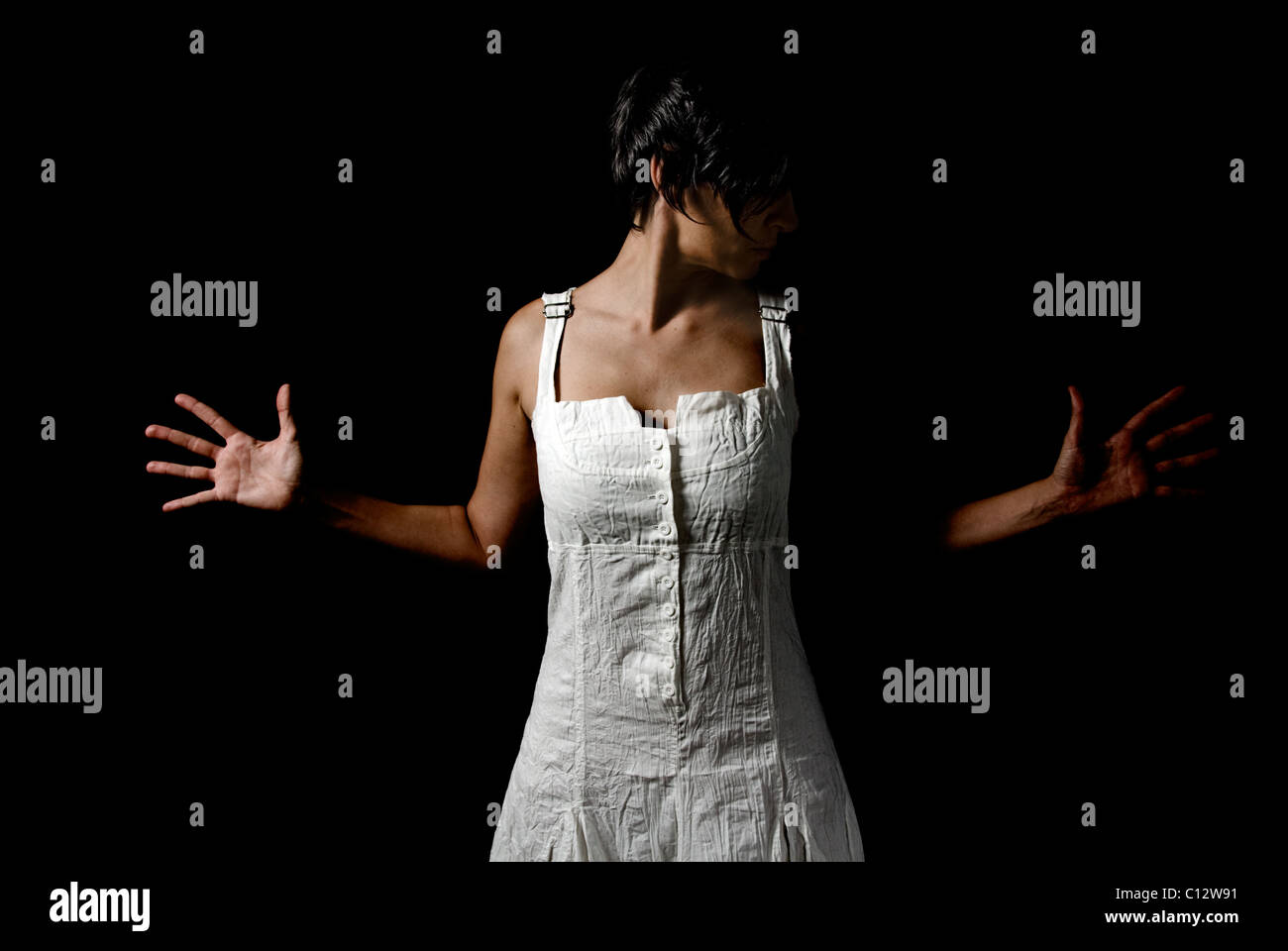 Femme en robe blanche avec des mains tendues Banque D'Images