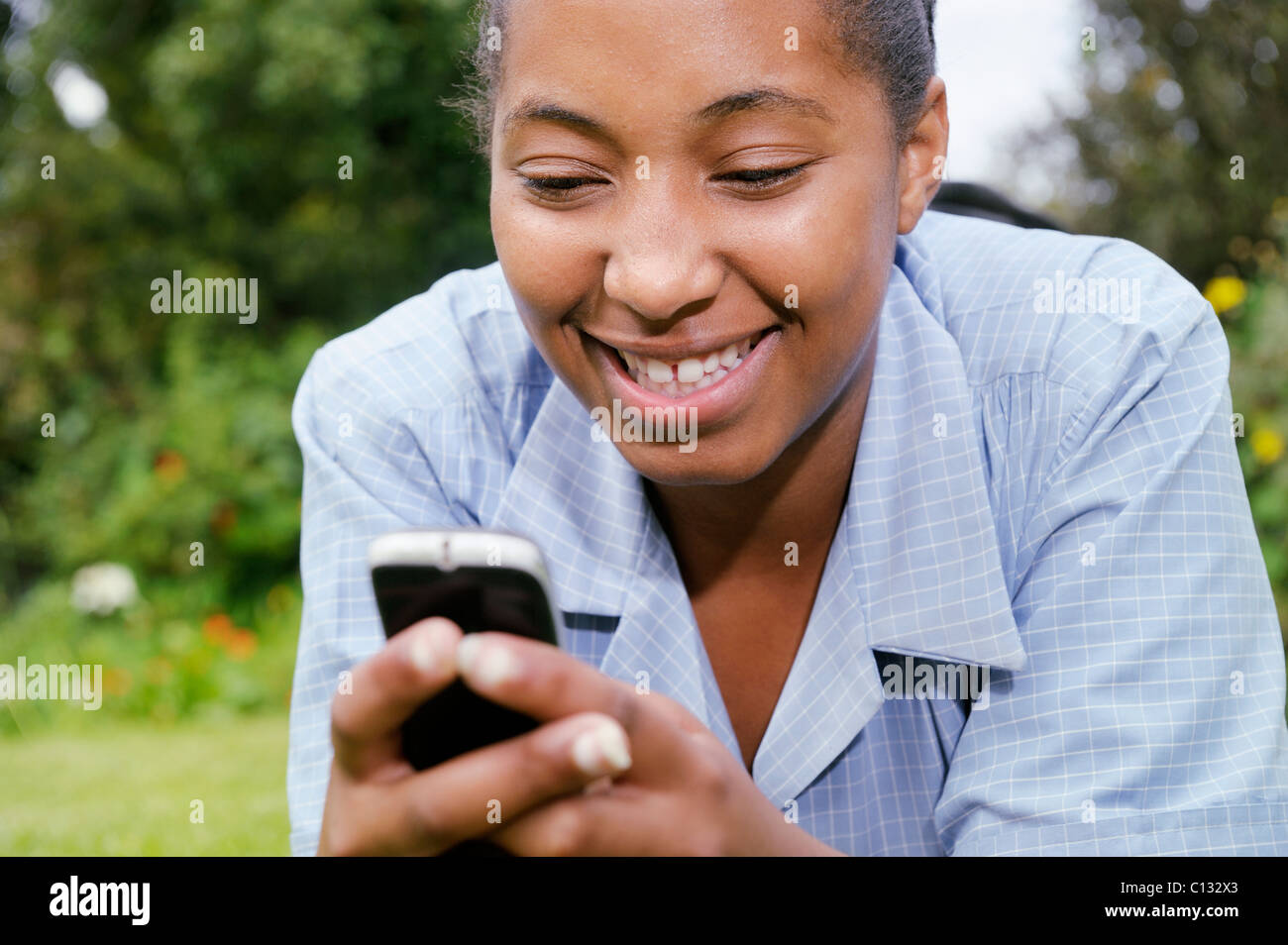 Fille de l'école d'apprécier quelque chose sur son téléphone portable, Le Cap, Afrique du Sud Banque D'Images