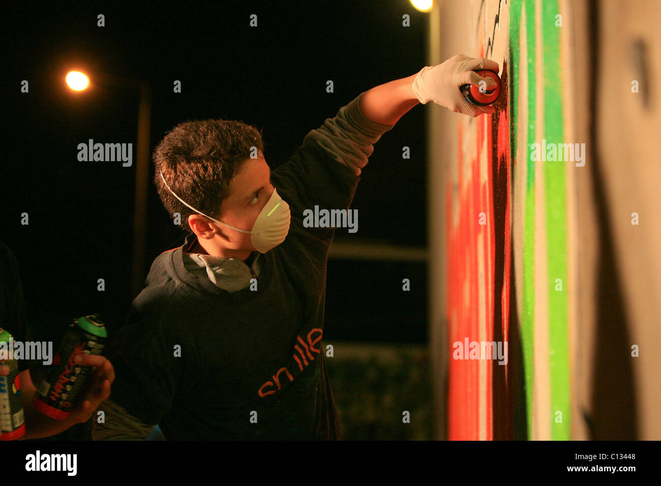 Les jeunes adolescents de peindre un graffiti sur un mur Banque D'Images