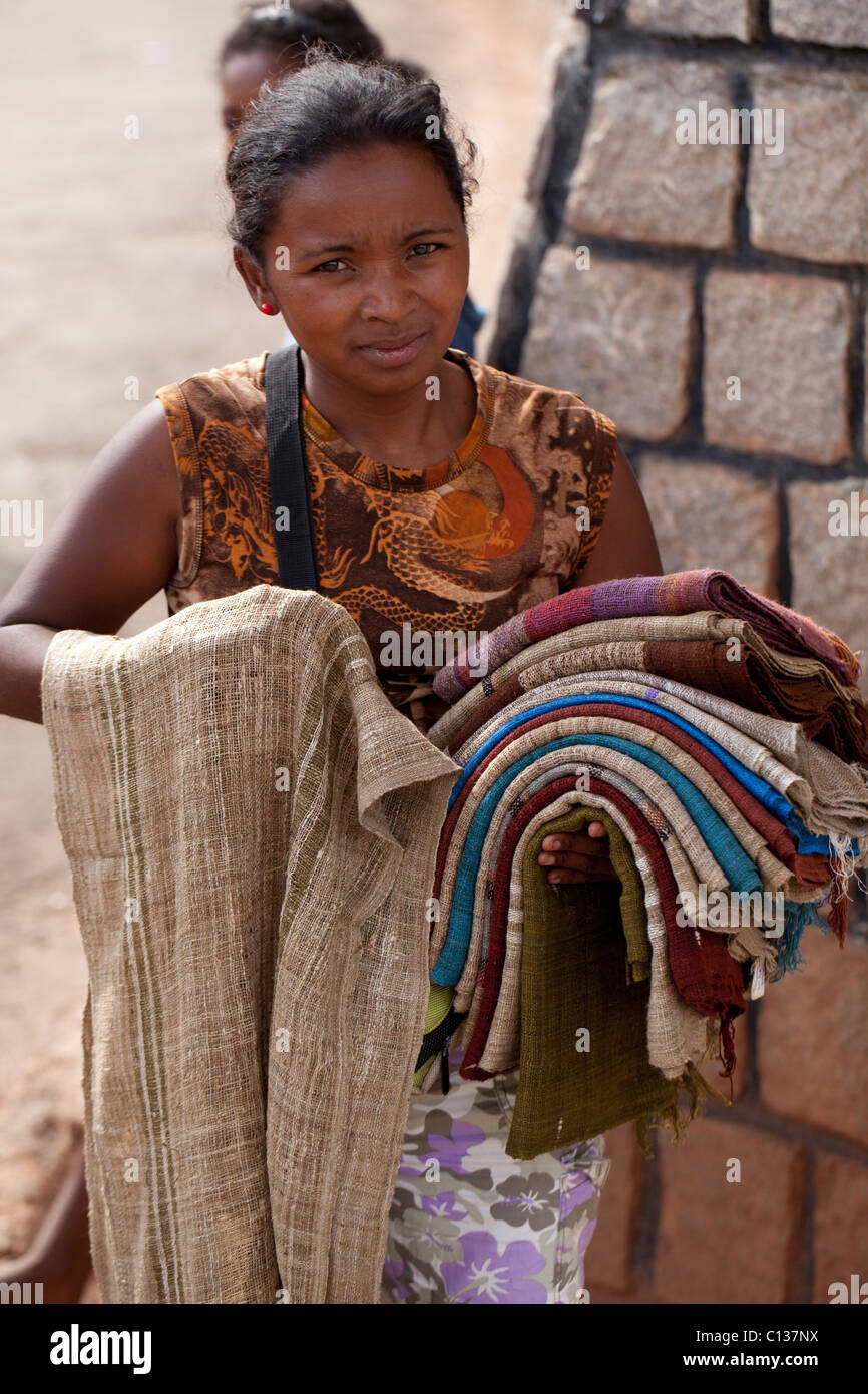Femme en négociant des textiles tissés localement. À Antsirabé. Centre-est de Madagascar. Banque D'Images